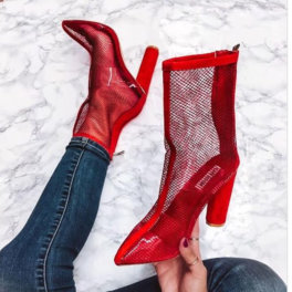 woman wearing a heel while holding the other pair