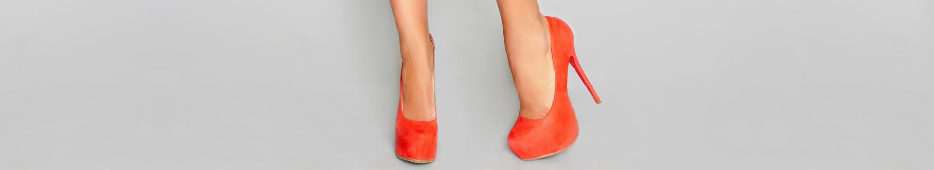 woman's feet wearing orange high heels